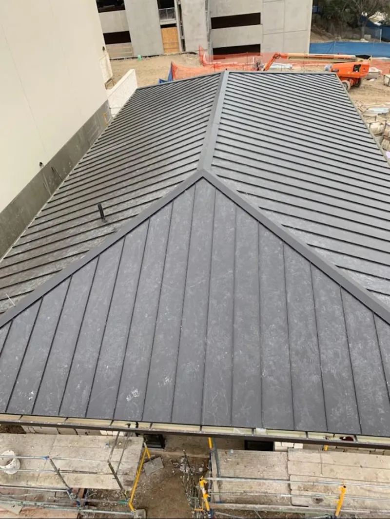 Commercial metal roof construction with crane equipment in Fox Crossing