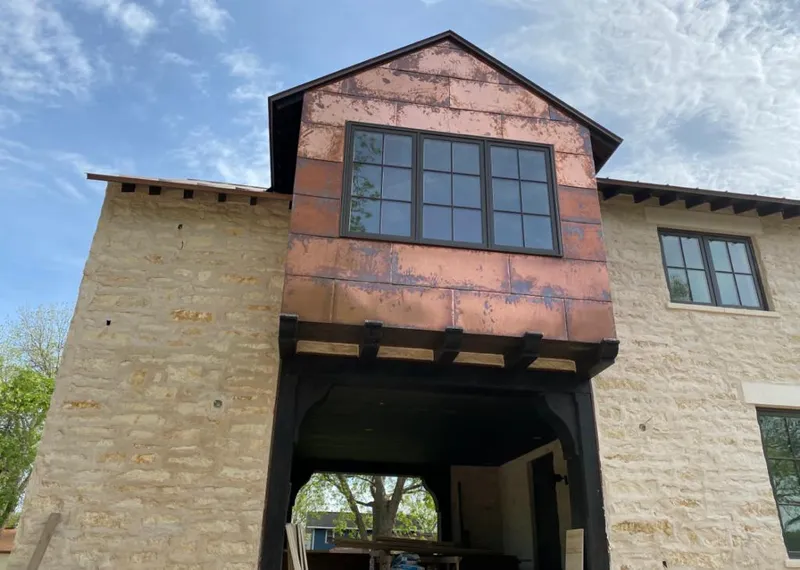 Copper metal panel facade on a stone building for Skylight Installation in Fox Crossing